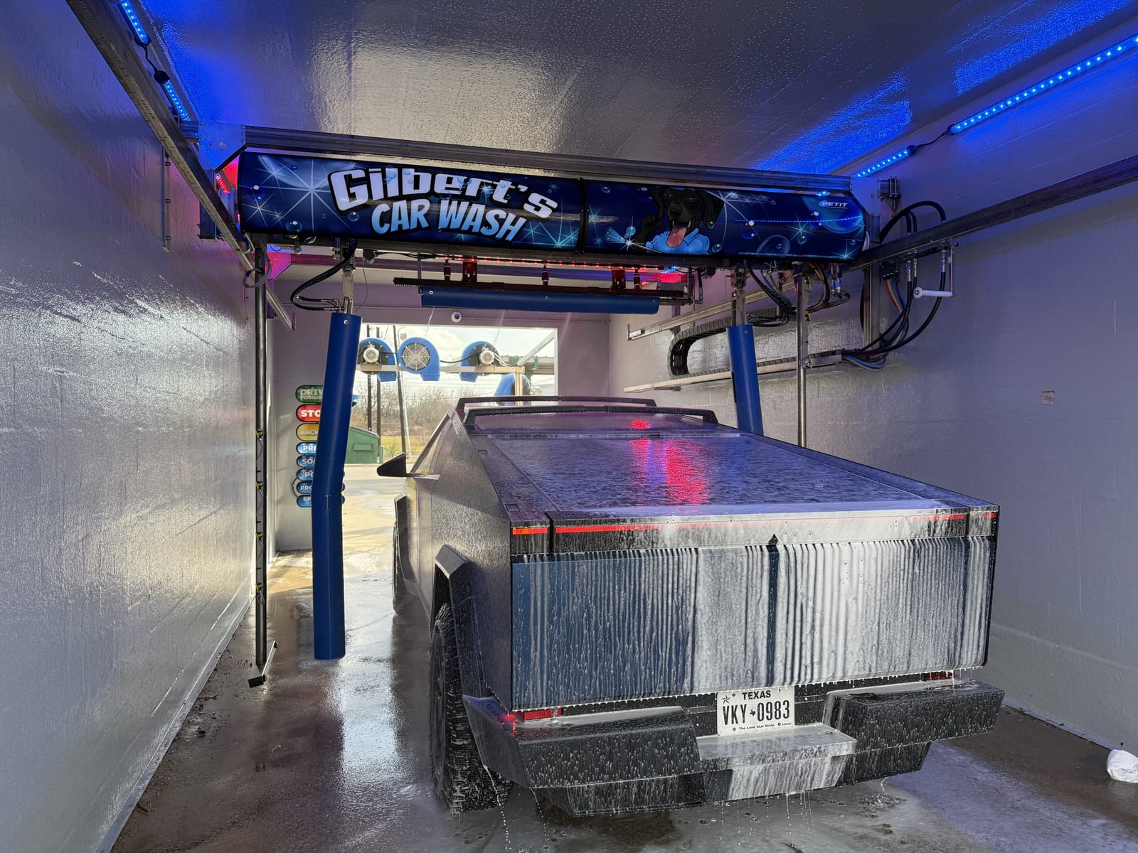 Vehicle entering the touchless automatic wash at Gilbert's Car Wash Victoria — presoak phase in action
